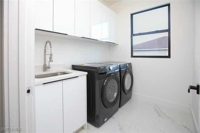 laundry room featuring washer and dryer, cabinets, and sink