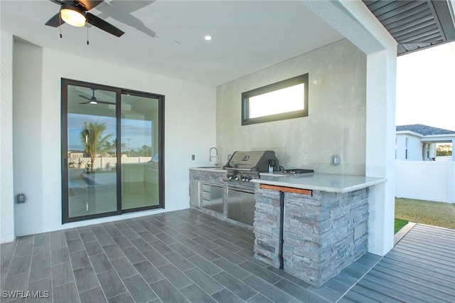 view of patio / terrace featuring a grill, ceiling fan, exterior kitchen, and a wet bar