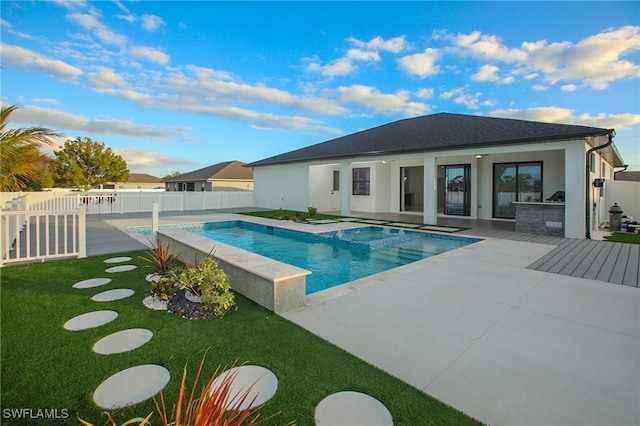 view of pool featuring a patio area, an in ground hot tub, a yard, and an outdoor kitchen