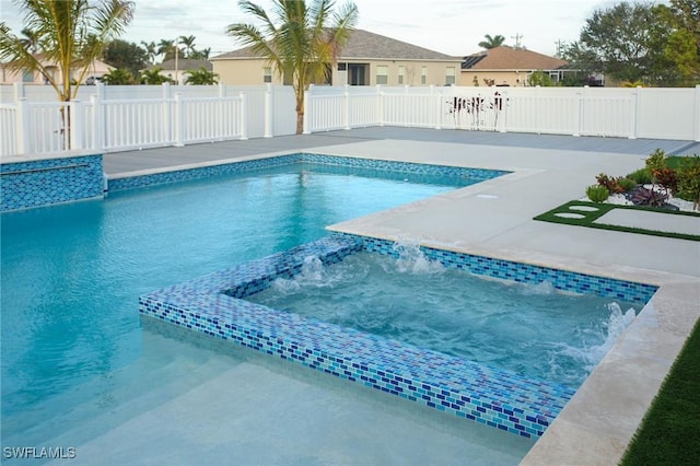 view of pool with pool water feature and a hot tub