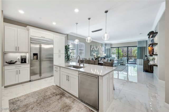 kitchen featuring white cabinets, appliances with stainless steel finishes, pendant lighting, and sink