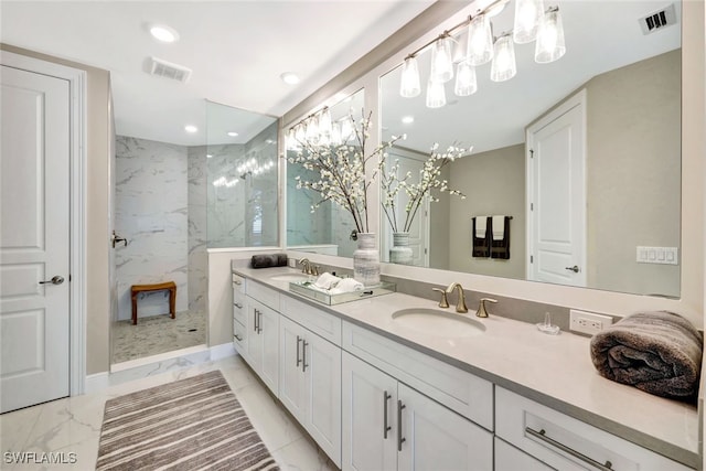 bathroom with a tile shower and vanity