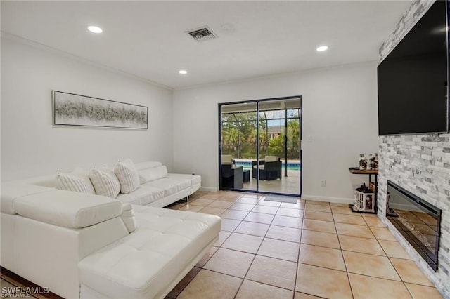 living room with crown molding, a fireplace, and light tile patterned floors