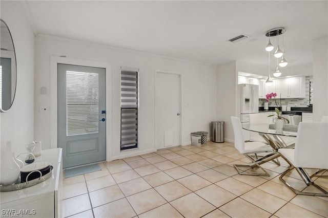 tiled dining room featuring ornamental molding