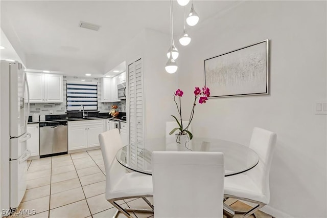 dining space featuring light tile patterned floors and sink