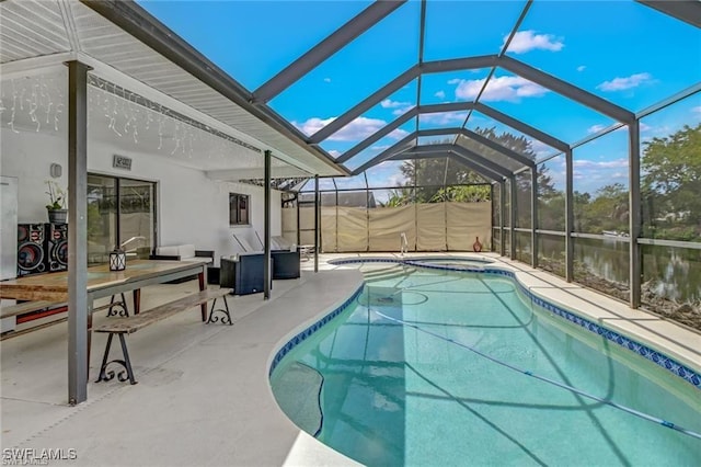 view of swimming pool with a lanai, a patio area, a water view, and a hot tub