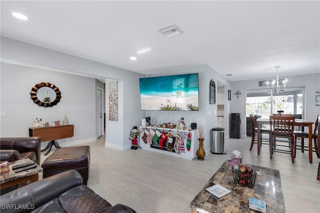 living room featuring light hardwood / wood-style floors and an inviting chandelier