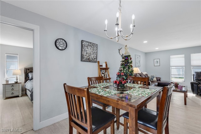 dining area featuring light hardwood / wood-style flooring and an inviting chandelier