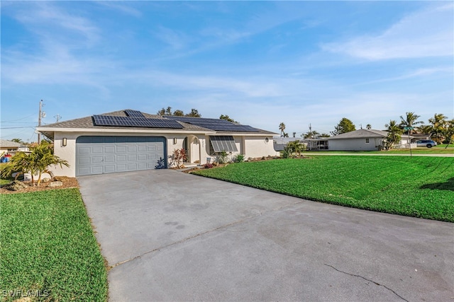 ranch-style home featuring stucco siding, a front yard, roof mounted solar panels, a garage, and driveway