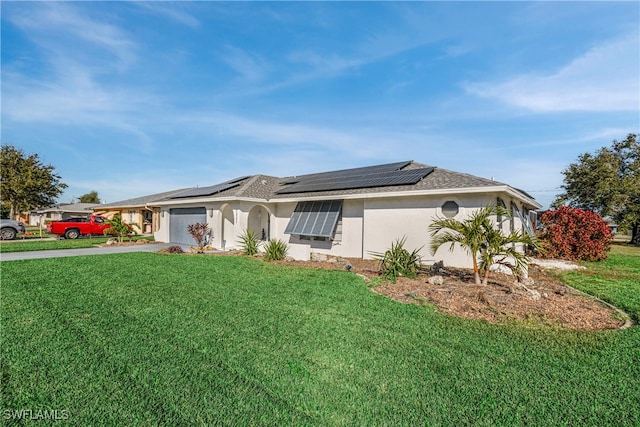 view of front of house featuring stucco siding, solar panels, concrete driveway, a garage, and a front lawn