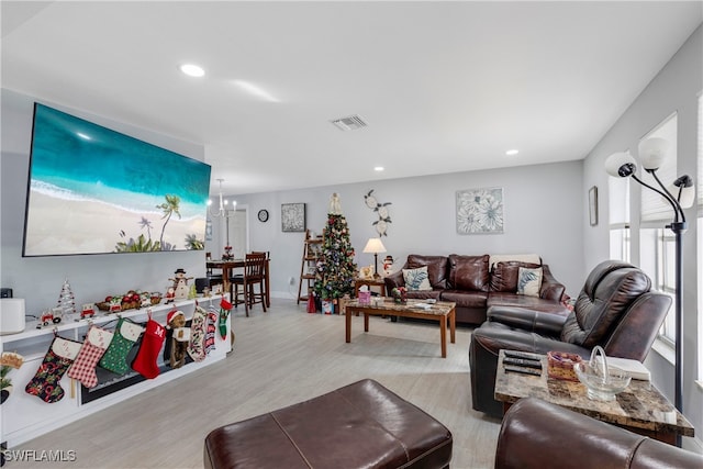 living room featuring a chandelier and light hardwood / wood-style flooring