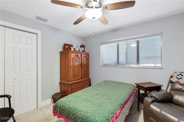 bedroom featuring ceiling fan, light colored carpet, and a closet