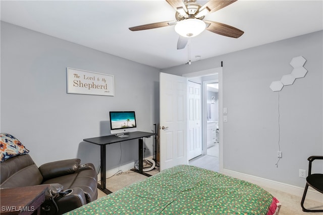 bedroom featuring light carpet, connected bathroom, a ceiling fan, and baseboards