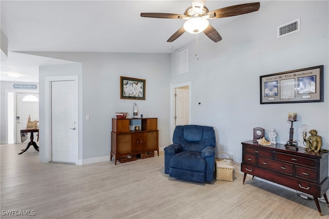 living area featuring ceiling fan, light hardwood / wood-style flooring, and lofted ceiling