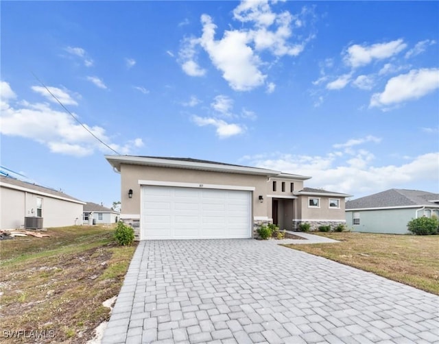 view of front of property featuring a garage, a front lawn, and central AC unit