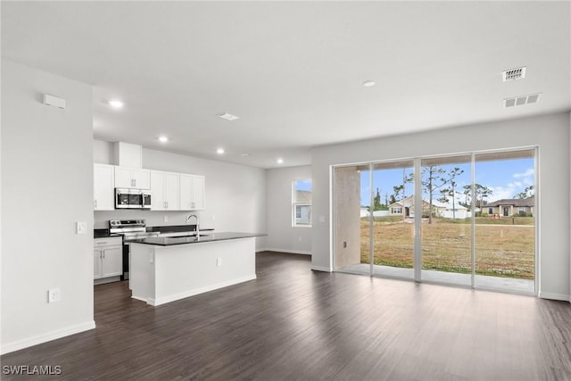 kitchen featuring a center island with sink, sink, white cabinetry, stainless steel appliances, and dark hardwood / wood-style flooring