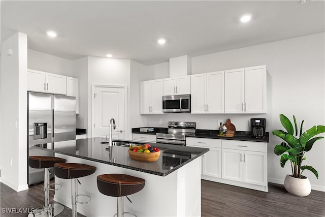 kitchen featuring white cabinets, sink, stainless steel appliances, and a center island with sink