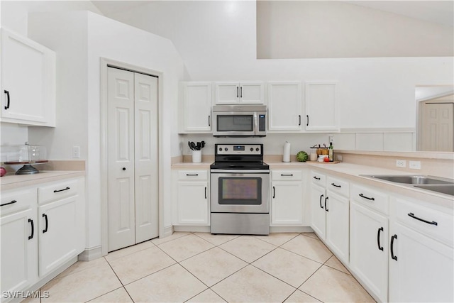 kitchen with light tile patterned flooring, appliances with stainless steel finishes, and white cabinets