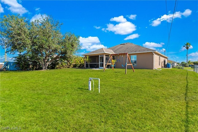 back of house featuring a sunroom and a lawn