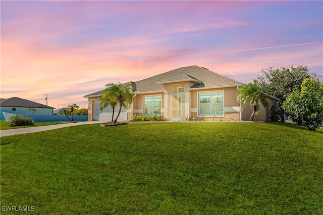 view of front of home with a yard and a garage