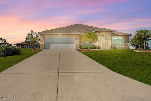 view of front of property with a garage and a yard