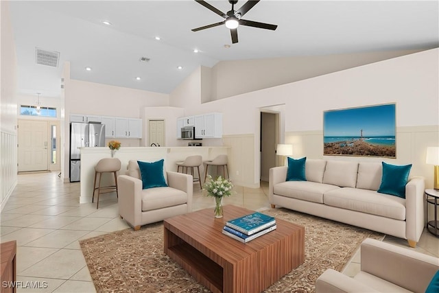 tiled living room with ceiling fan and high vaulted ceiling