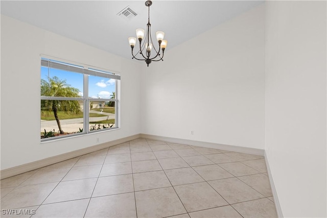 tiled empty room with an inviting chandelier