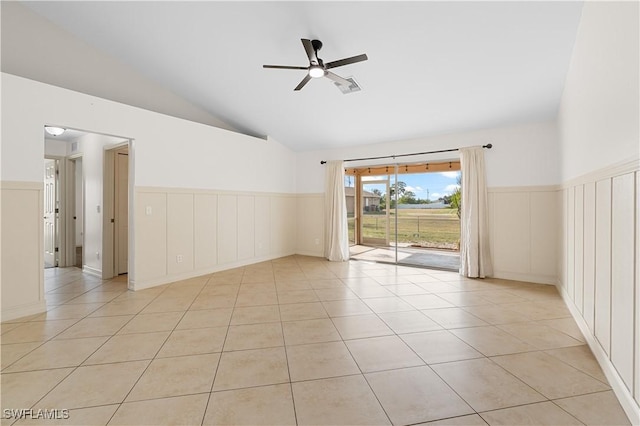 empty room featuring vaulted ceiling, light tile patterned flooring, and ceiling fan