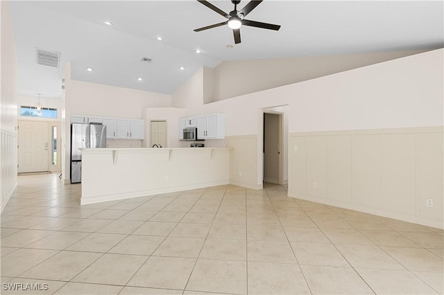 unfurnished living room with ceiling fan, high vaulted ceiling, and light tile patterned floors