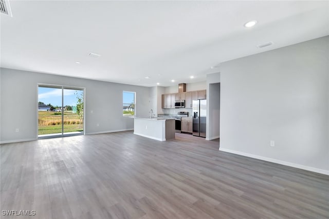 unfurnished living room with sink and light hardwood / wood-style flooring