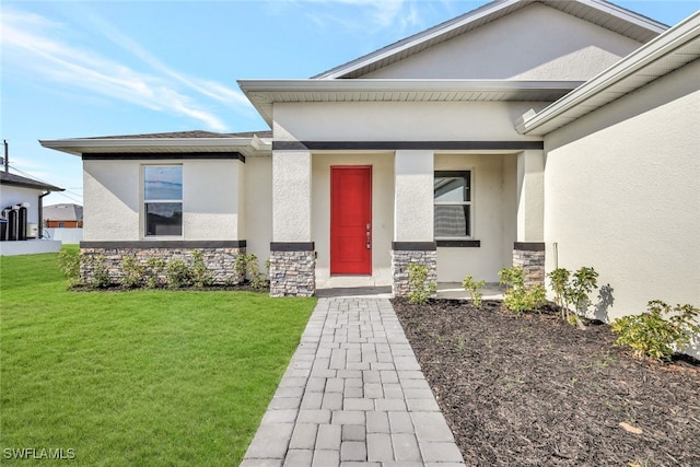 entrance to property featuring a lawn