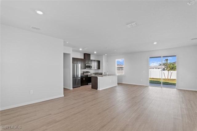 unfurnished living room featuring light hardwood / wood-style flooring and sink