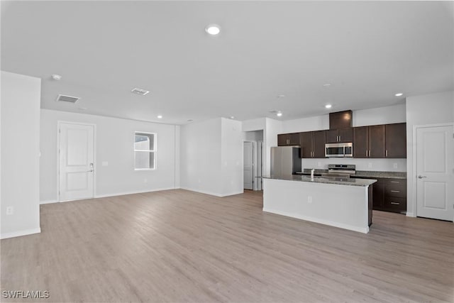 kitchen featuring dark brown cabinetry, stainless steel appliances, a kitchen island with sink, sink, and light hardwood / wood-style floors