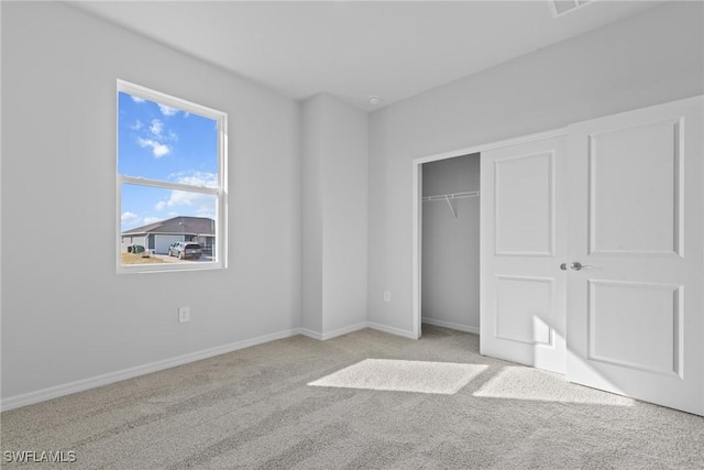 unfurnished bedroom featuring light colored carpet and a closet