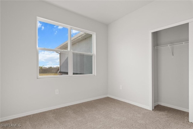 unfurnished bedroom featuring light carpet and a closet