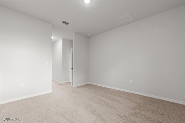 spare room featuring light colored carpet