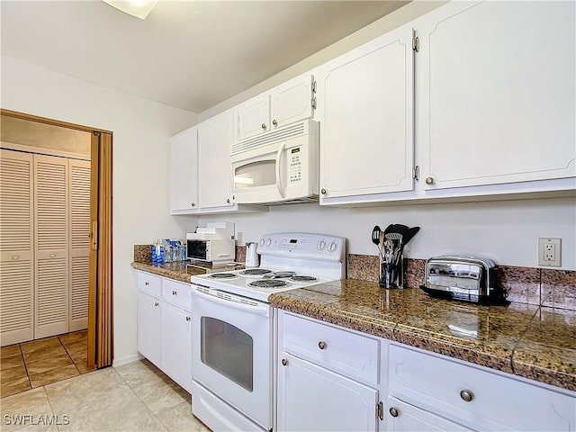 7397 Grande Pine Rd, Bokeelia, FL 33922 - kitchen with white cabinets, light tile patterned floors, and white appliances