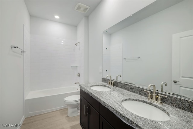 full bathroom with shower / bathing tub combination, hardwood / wood-style flooring, vanity, and toilet