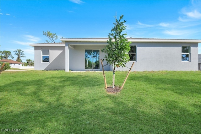 rear view of house featuring a yard