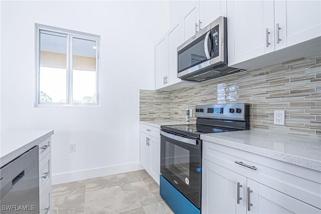 kitchen with light stone counters, white cabinets, baseboards, appliances with stainless steel finishes, and tasteful backsplash