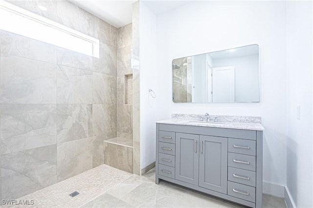 full bath with baseboards, a walk in shower, and vanity