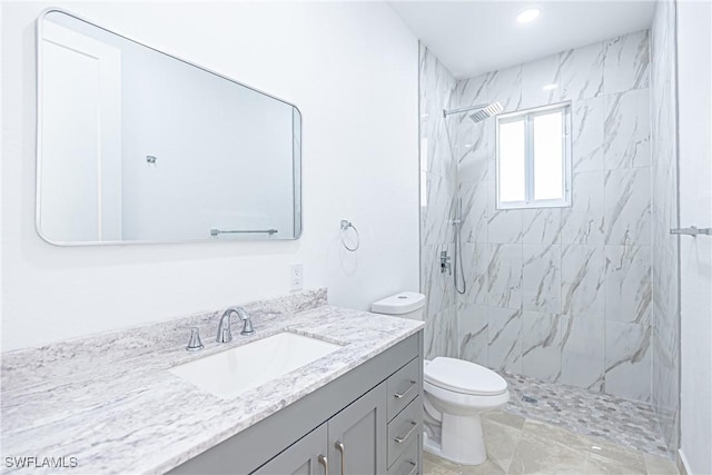 full bathroom featuring toilet, a marble finish shower, and vanity