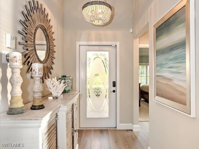 entryway featuring light wood-type flooring and an inviting chandelier