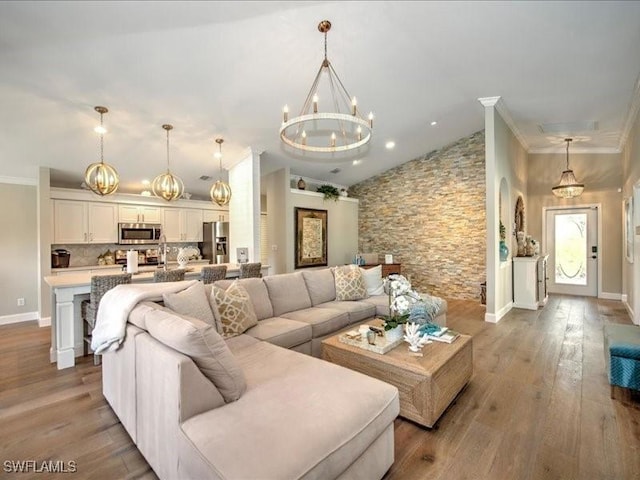 living room featuring a notable chandelier, crown molding, and light hardwood / wood-style flooring