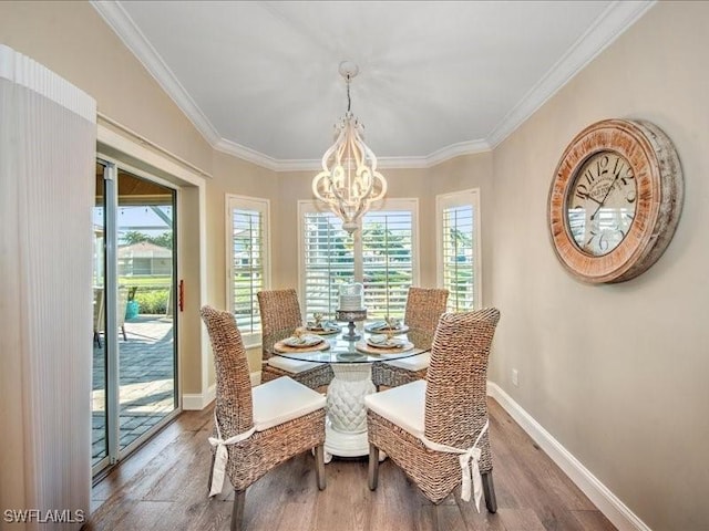 dining space featuring a chandelier, hardwood / wood-style floors, a wealth of natural light, and crown molding