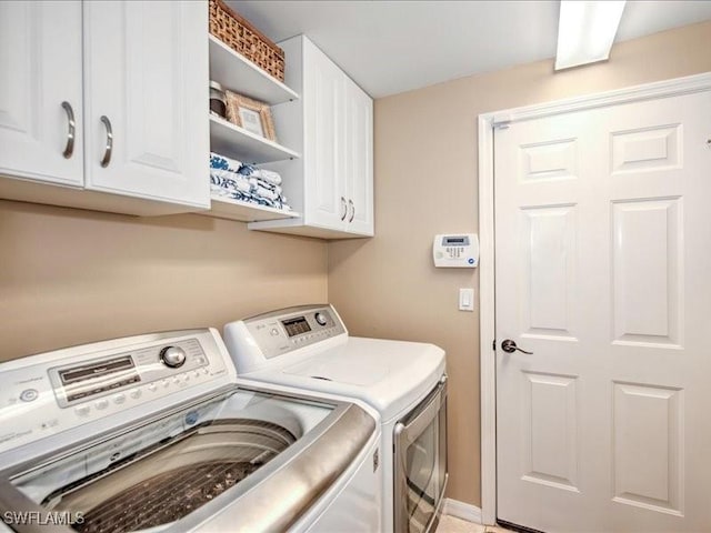 laundry area featuring cabinets and washing machine and clothes dryer