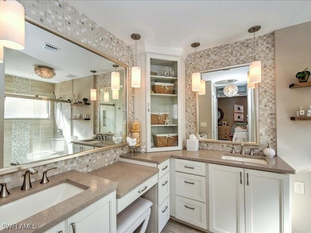 bathroom with decorative backsplash, vanity, and an enclosed shower