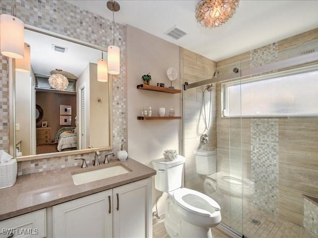 bathroom with decorative backsplash, vanity, a shower with shower door, and toilet