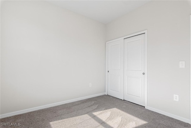 unfurnished bedroom with a closet and carpet floors