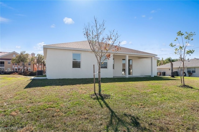 back of property with a yard and central air condition unit